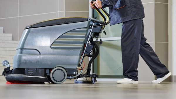 worker cleaning floor with machine